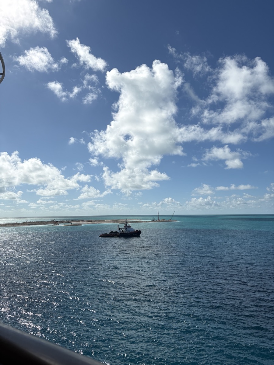 Turquoise water and a working boat viewed from a cruise ship